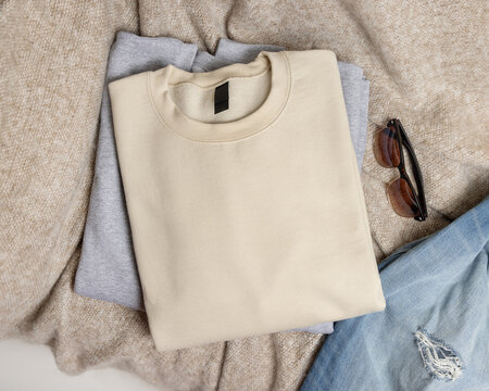 Blank beige unisex sweatshirt mockup, folded crewneck casual flat lay with copy space on front