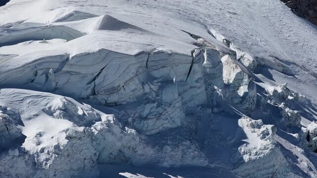 Sunny drone view of Tignes and Grande Motte glacier surrounded by snowy mountains in the French Alps during spring. Drone view of alpine glacier and snowy mountain peaks in French Alps