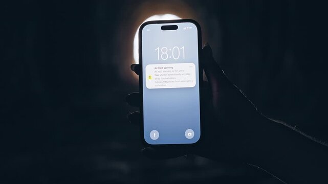 Smartphone Showing Air Raid Warning Notification in Dark Tunnel With Bright Light Background, Cinematic Emergency Scene About Civil Defense and Survival