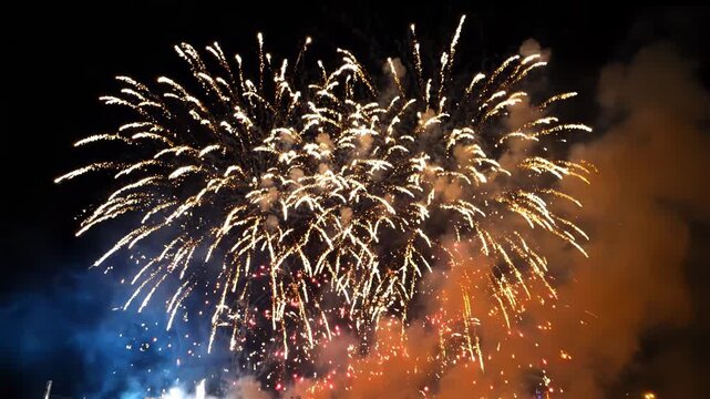 Vibrant fireworks exploding in the night sky with colorful smoke