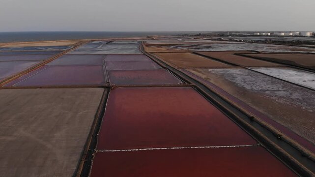 Aerial view of salt harvesting ponds over coastal Thailand, crystal salt ponds.