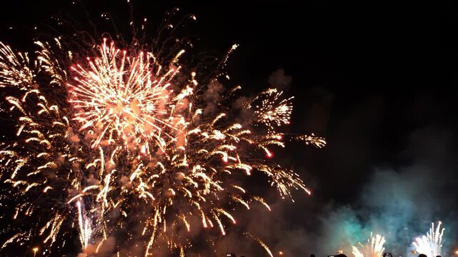Vibrant fireworks exploding in the night sky with colorful smoke