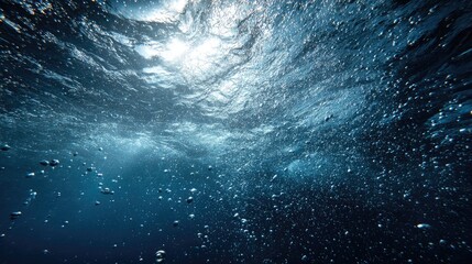 Fototapeta premium Underwater View of Sunlight Filtering Through Rippling Water Surface with Bubbles.