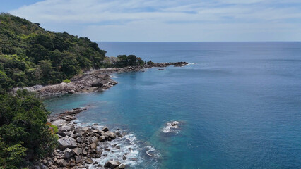 Fototapeta premium Aerial View of Lush Green Hills and Rocky Coastline in Phuket