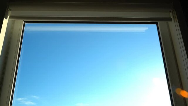 Window with partially drawn blind and blue sky highlighting vibrant colors and contemporary design