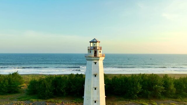 Lighthouse framed by ocean and coastal greenery