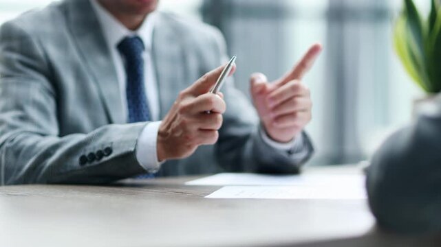 Man in business attire holds pen, poised to sign document