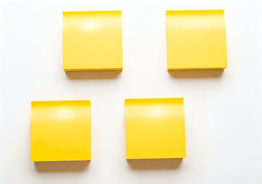 Set of four vibrant blank yellow sticky notes with shadows, ready for important messages, reminders, or creative ideas on a clean white surface