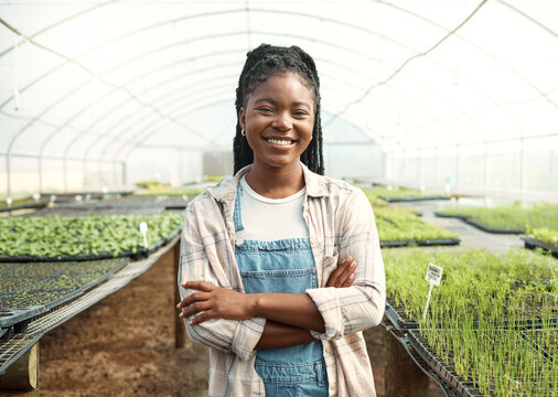 Smile, black woman and farmer with arms crossed in for agriculture, sustainable and plant growth. Portrait, person and farming with food production, harvest crops and organic produce in greenhouse