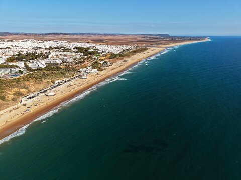 aerial view of the beautiful beach Playa de la Fontanilla, hotels and old town in Conil de la Frontera at a sunny summer day, Andalusia, Costa de la Luz, Spain