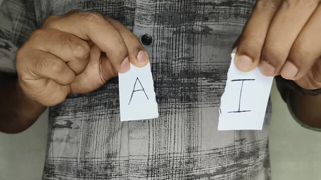 Hands of employee or person who loss job and become unemployed beacouse of artificial intelligence ripping paper with AI word written on it. AI scams, concerns, threat and job displacement concept.