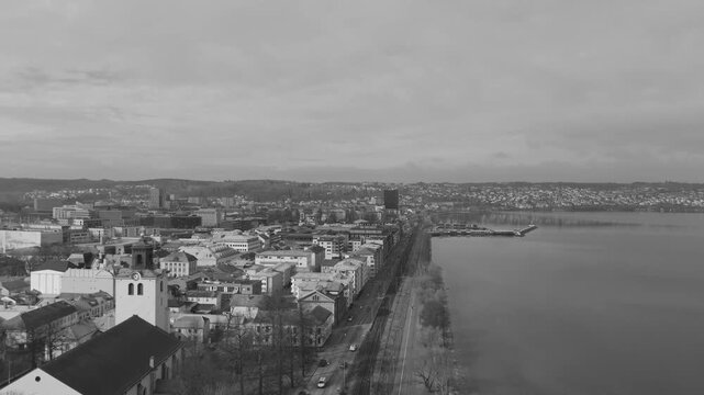 Black and white aerial drone shot of Jonkoping featuring Sofia Church near waterfront with long coastal road along Lake Vattern creating classic urban panorama