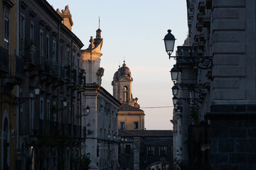 Obraz premium Traditional italian street view with vintage lamps and historic church dome in Catania