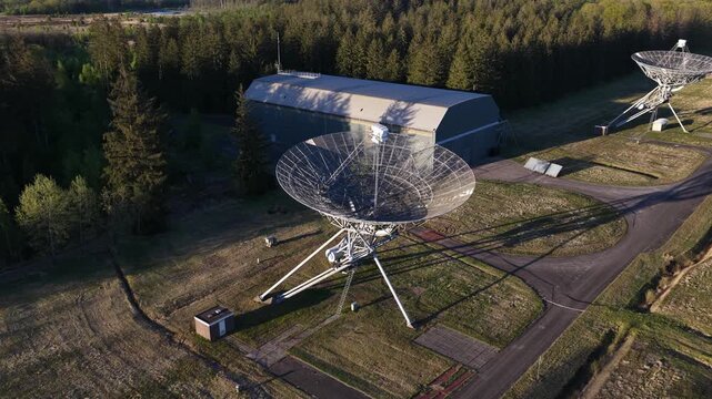 Aerial view of a radio telescope array with large parabolic dishes scanning the sky, an observatory network symbolizing astronomy research, seti, space communication and cosmic signal detection