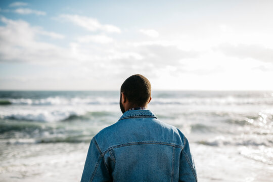 Back view of young man looking at the sea