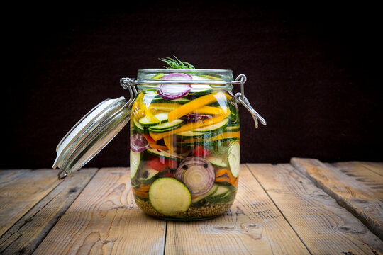 Glass of pickled courgette and bell pepper