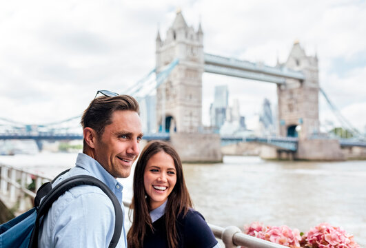UK, London, smiling couple with the Tower Bridge in the background