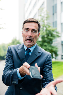 Shocked businessman with cell phone in the city