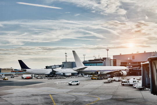 Airplanes and vehicles on the apron at sunset