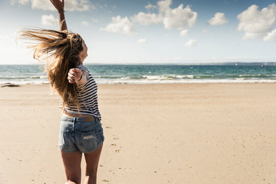 Happy young woman dancing on the beach