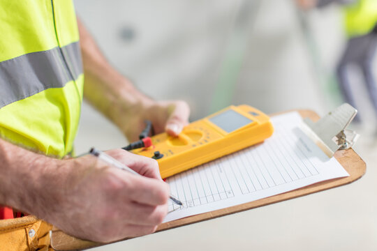 Close-up of electrician taking notes
