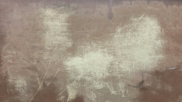 Cracked rusty metal sheet texture with faded stains. Grunge industrial rusty iron plate background with crack. Textured backdrop of a heavily oxidized metallic wall with a structural crack.