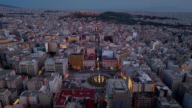 Aerial view of the city skyline of Athens, Greece, from Omonia Square following Athinas Street until the Acropolis hill during dusk