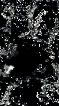 Splashes of water take off and rotate in flight. Top view. On a black background. Filmed on a high-speed camera at 1000 fps.