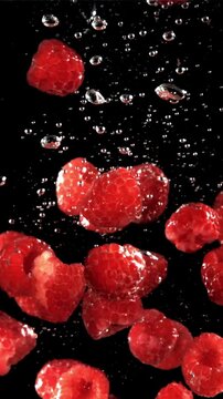 Fresh raspberries fall underwater with bubbles. Filmed is slow motion 1000 fps. High quality FullHD footage