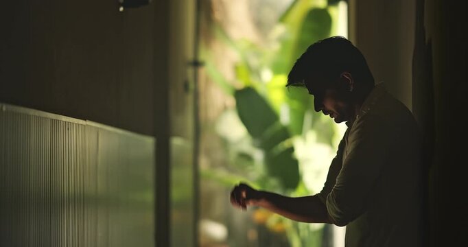 Indian young adult gen z sad stress man guy look upset feel bad hurt head ache in dark living room. Alone tired male boy think deep suffer low health issue lost job fail guilt indoor house home place