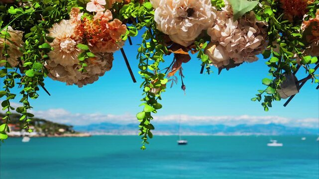 Beautiful flower decoration swaying in wind against turquoise sea and blue sky on sunny day.