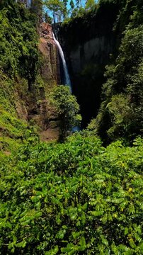 Breathtaking high angle shot of iconic Kapas Biru waterfall &ndash; Epic wild nature landscape with powerful water stream hidden in lush green jungle canopy, Java Indonesia commercial stock footage