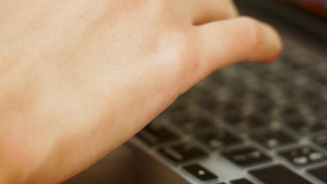 Fingers quickly typing on a modern laptop with dual language keyboard