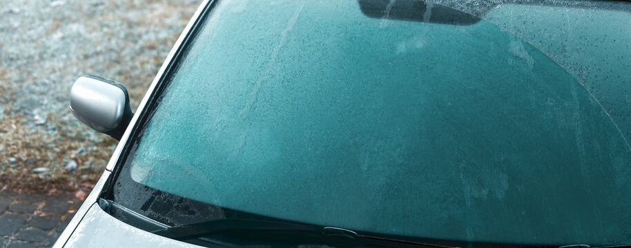 Car windshield obscured by ice and frost in winter
