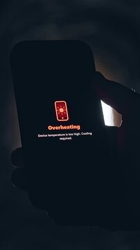 Vertical video. Smartphone Displaying Overheating Warning Inside Dark Underground Tunnel, Cinematic Device Failure Scene About Technology Stress and Critical Temperature