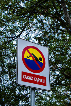 Znak zakaz kąpieli na tle drzew