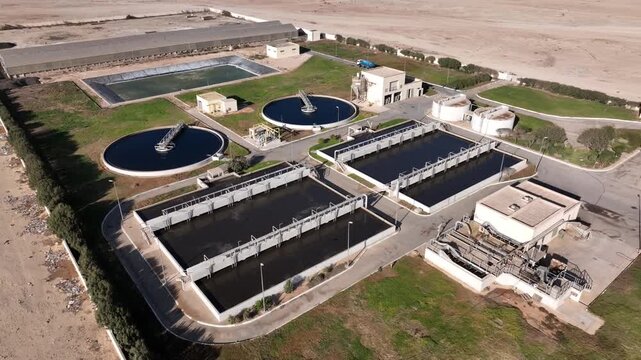 Aerial drone view of industrial water treatment plant with circular tanks and engineering infrastructure in Dakhla Morocco ideal for environmental projects
