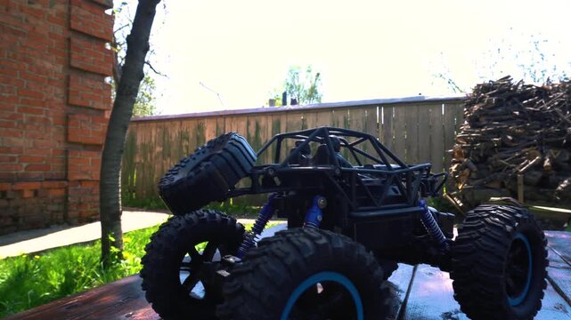 off-road toy cars turn with big tires art creative in water splashes 360 degree rotation on dark background with red backlight
