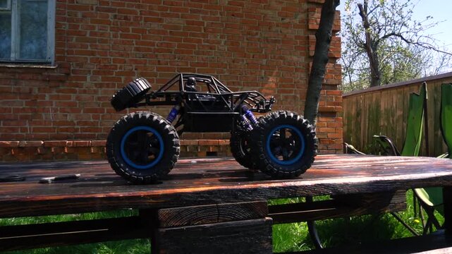 off-road toy cars turn with big tires art creative in water splashes 360 degree rotation on dark background with red backlight