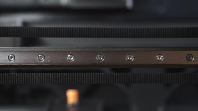 Timing belt and metal guide bar inside a 3D printer during print process