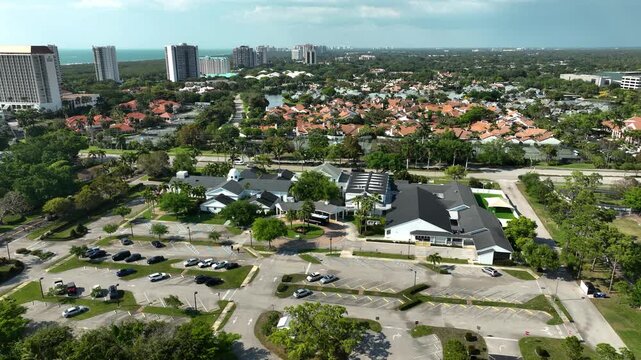 Drone footage of Naples United Church of Christ, showcasing its charming architecture, tennis courts, palm-dotted grounds, and the tranquil neighborhoods of Naples, Florida.