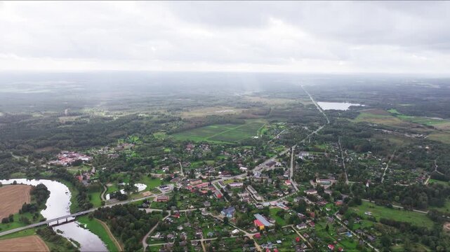 Skrunda Latvia from high altitude with drone tilt down, Venta river town layout
