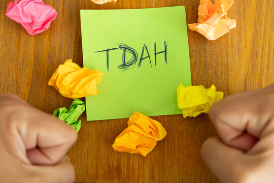 A person with their fists on the table while describing in a post the condition they believe they have: TDAH