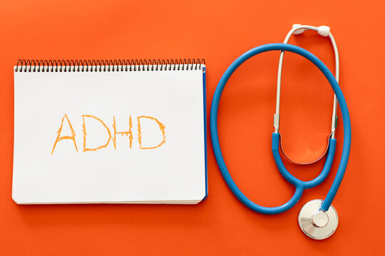 ADHD diagnosis concept with notebook and stethoscope on orange background
