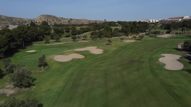 Flying over a green golf course with an arid background. Alenda golf club, Alicante, Spain.