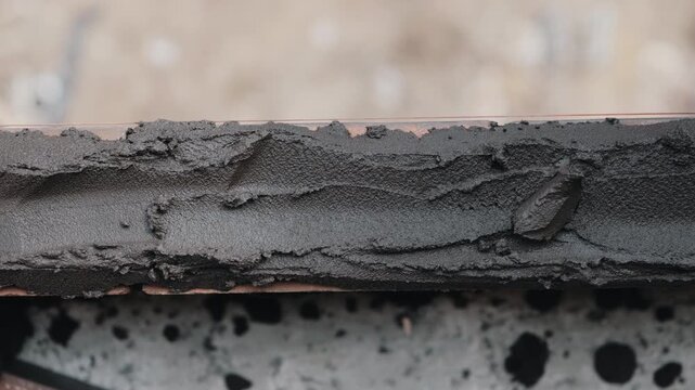 Fresh cement mortar layer on masonry block close up