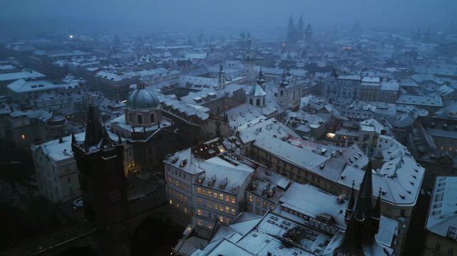 Aerial view of Prague Old Town district covered with fresh snow during winter twilight.