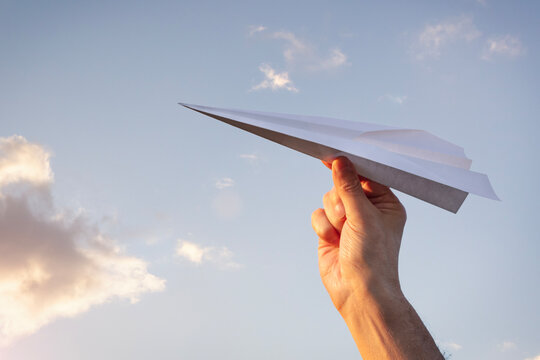 Paper airplane launch into sky at sunset