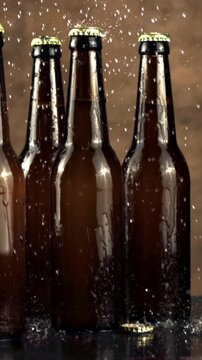 Super slow motion on closed glass beer bottles dripping water. On a brown background. Filmed on a high-speed camera at 1000 fps.