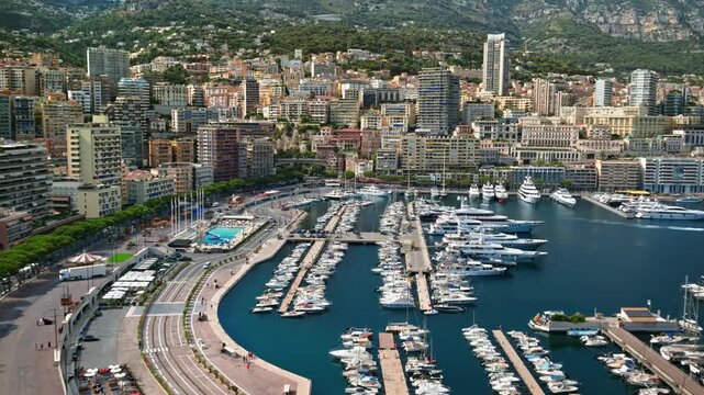 Aerial panoramic view of port hercules marina in monte carlo monaco showing luxury yachts and modern high rise apartment buildings.